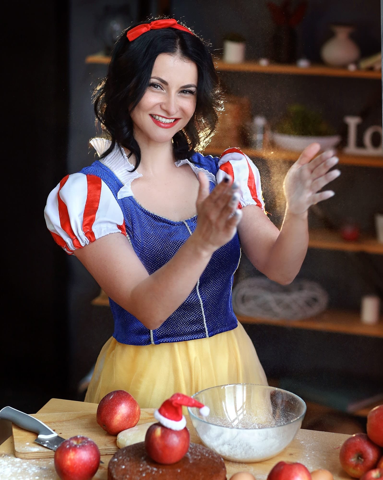a girl in the image of snow white from the Disney cartoon is preparing an apple pie