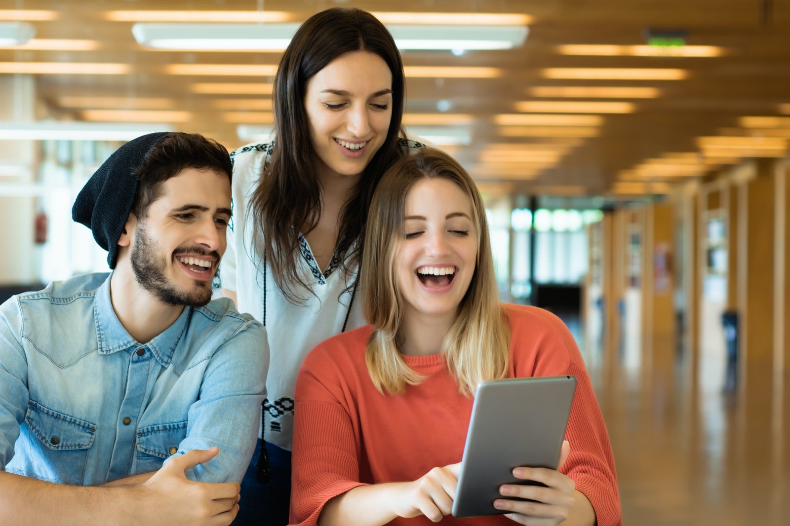 University students using digital tablet in university library.