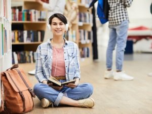 Multitasking girl reading book and listening to music
