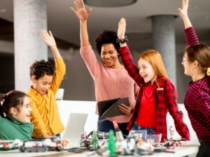 happy kids with their African American female science teacher with laptop