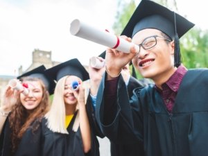 selective focus of multicultural graduates with diplomas in park