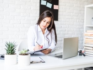 Young brunette teacher writing having online class