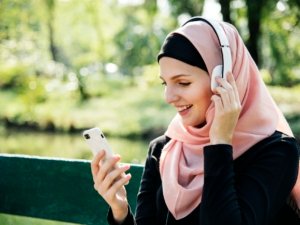 Islamic woman using mobile phone to listening music