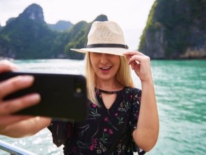 Woman in hat taking a selfie in Ha Long Bay Vietnam