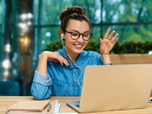 Smiling businesswoman having online conversation on her laptop in office