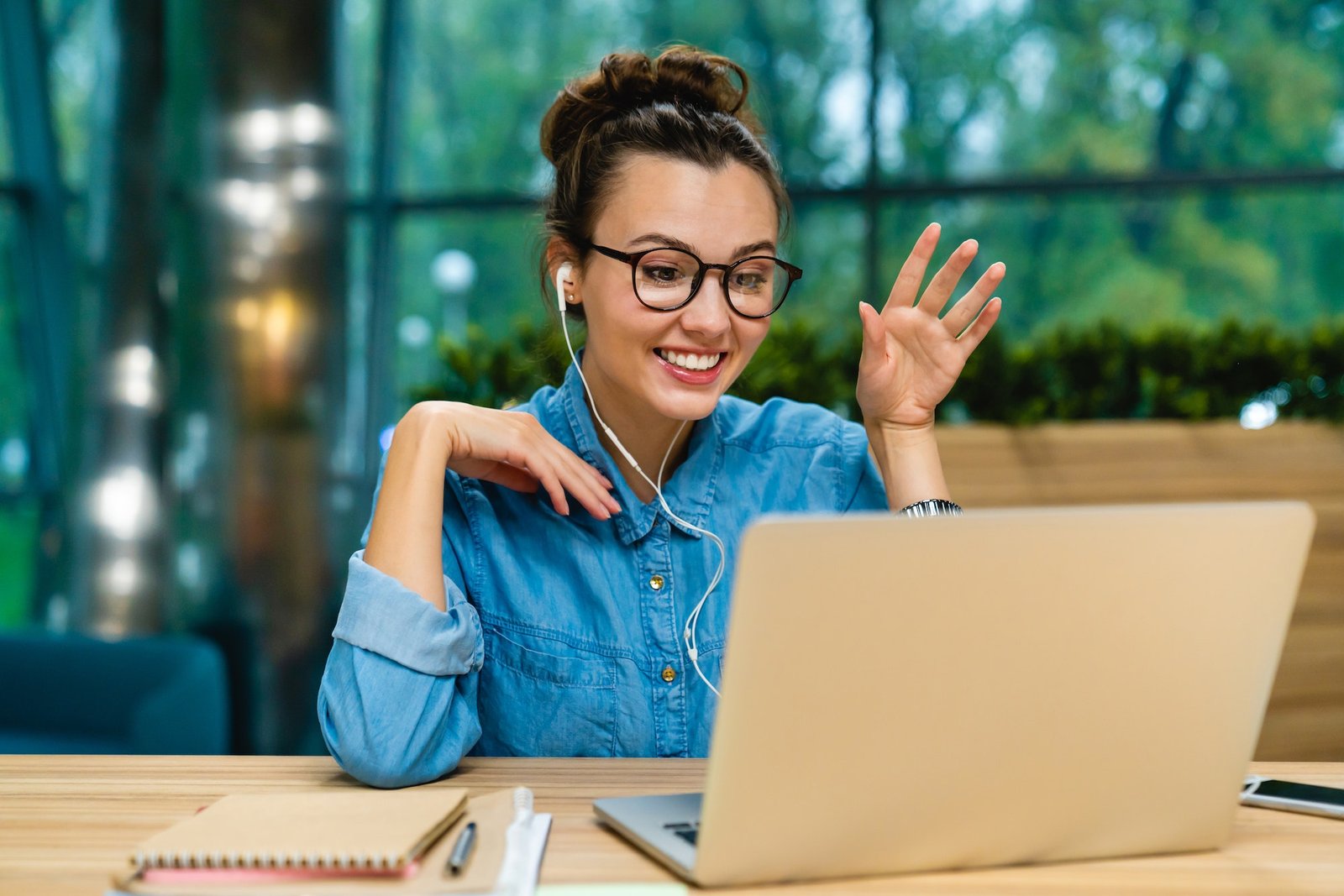 Smiling businesswoman having online conversation on her laptop in office