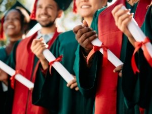 Close-up of students with graduation certificates.
