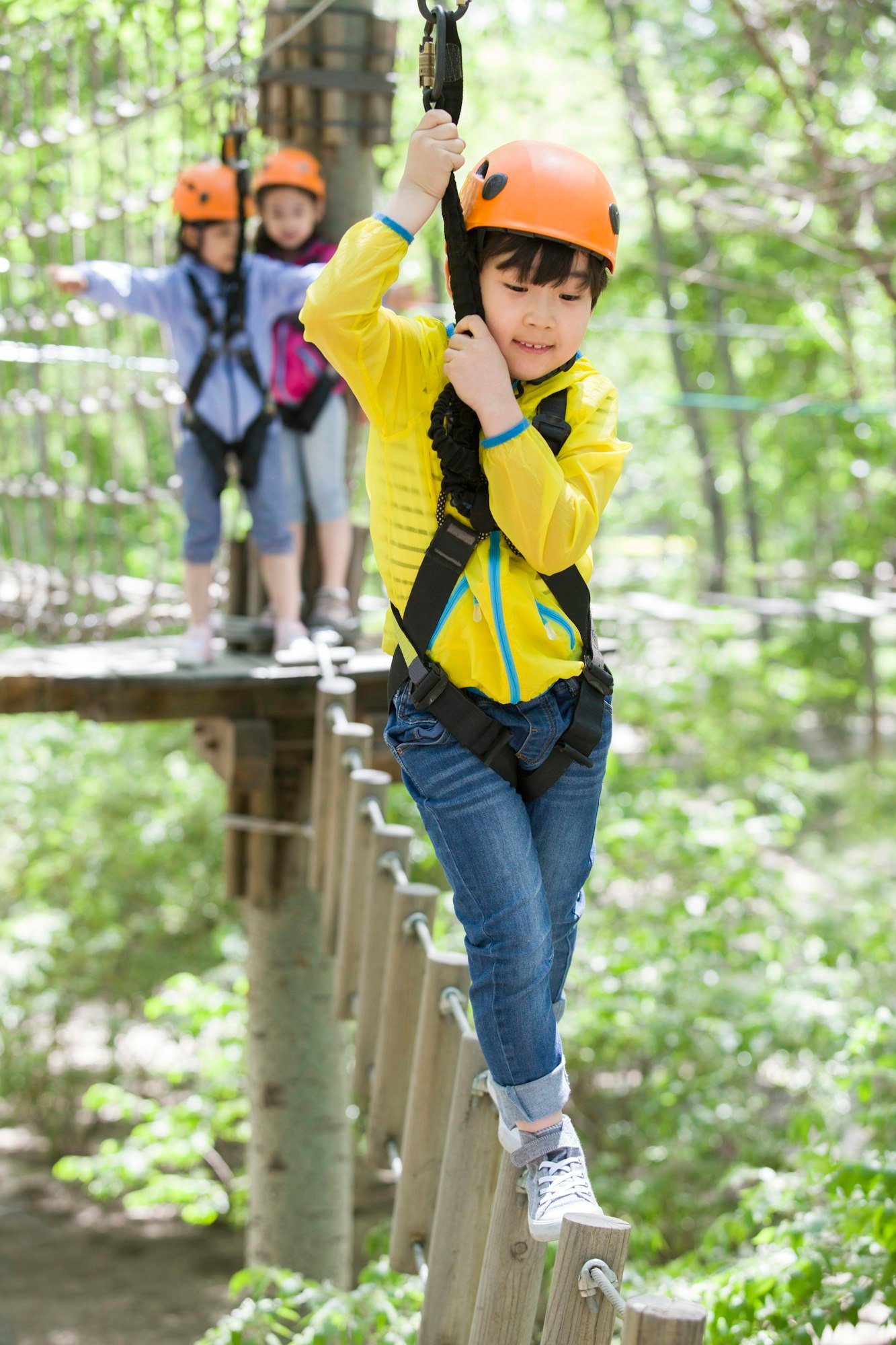 Happy children playing in tree top adventure park