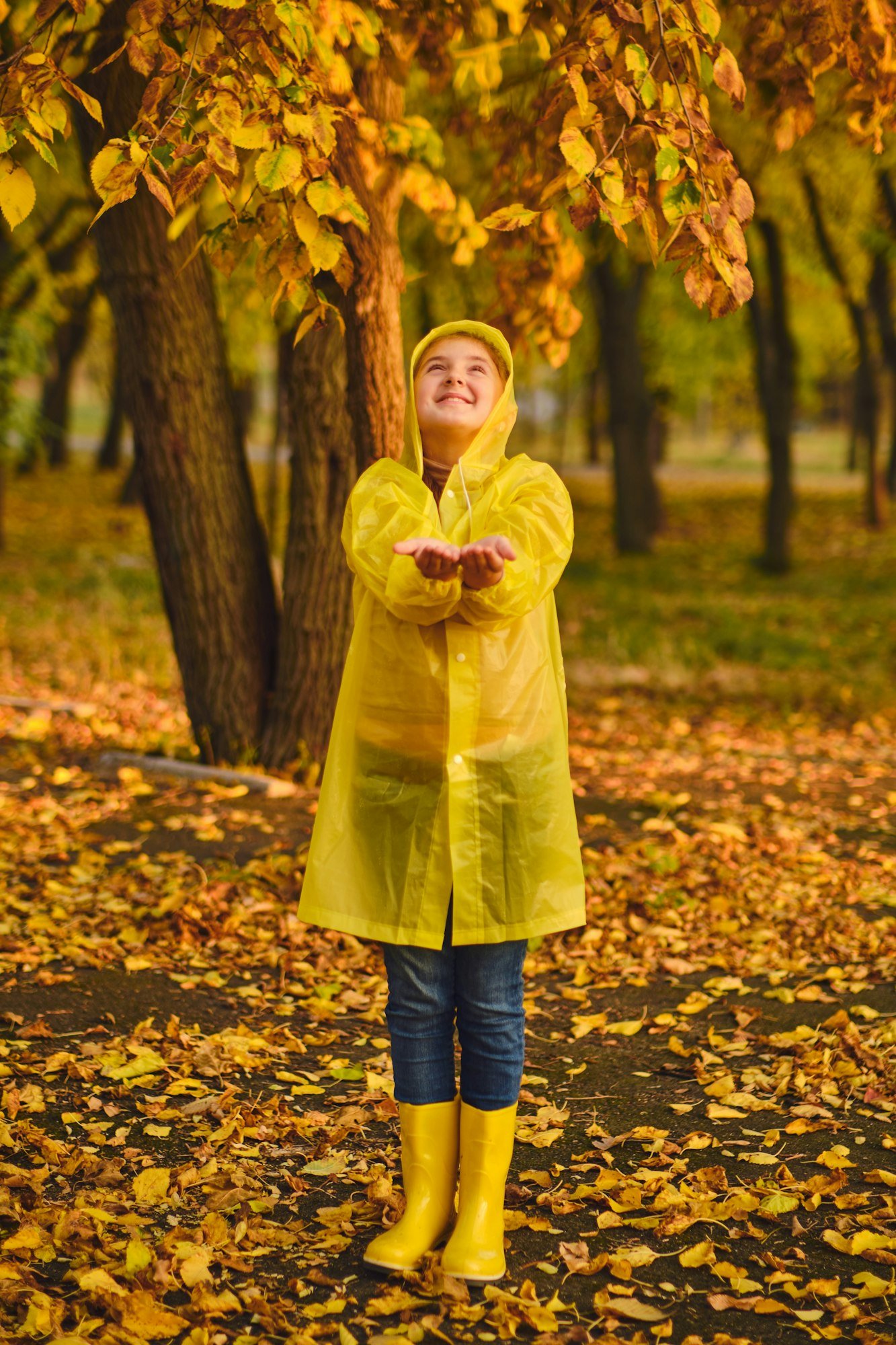 kid playing on the nature outdoors in autumn rain