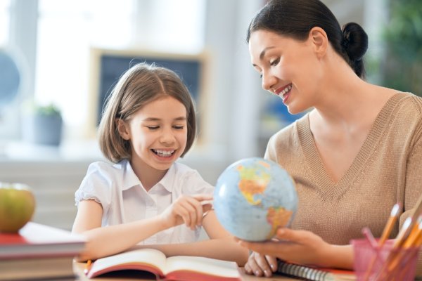 Girl with teacher in classroom.