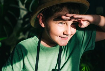 Little boy with binoculars and safari hat