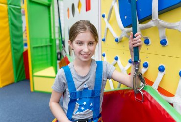 Teen girl in protection harness in entertainment center