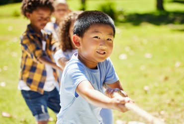 The winning team works as one. Shot of a group of kids playing a game of tug of war at summer camp.